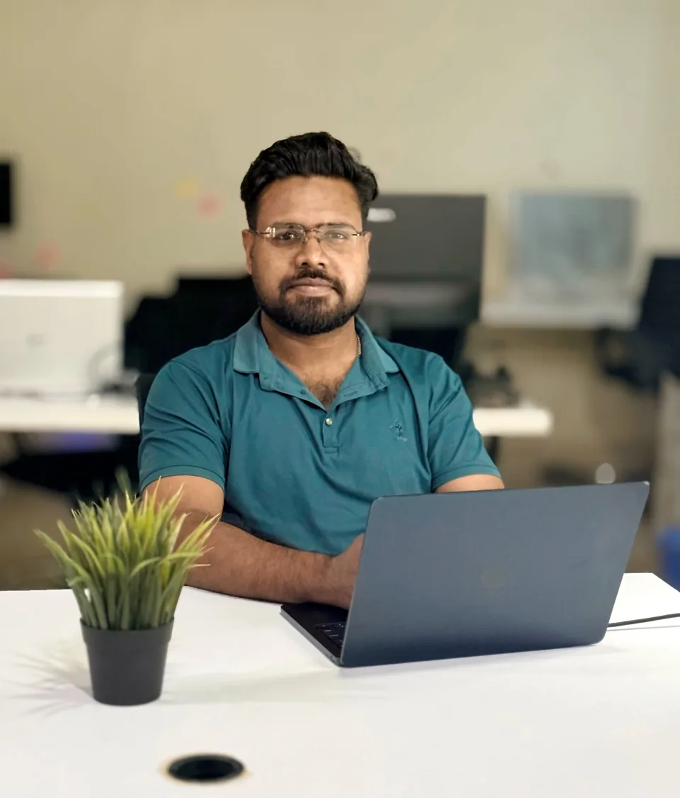 KMR Jibon seated at a laptop in the office